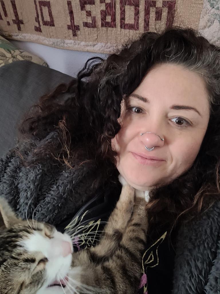 a woman cuddling with a yawning cat